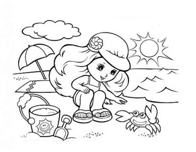 Девочка играет с крабом на берегу моря